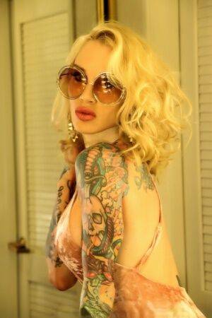 Tattooed blonde Sarah Jessie masturbates on a bathroom counter in spectacles on nudesceleb.com