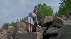 Barefoot girl Nastya squats for a piss on top of a bunch of boulders on nudesceleb.com