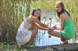 Young lesbians Nastya & Ashly get naked on a dock in the reeds on nudesceleb.com