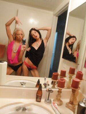 Skinny girls Kacey and Zoey showing off teenie tits while taking mirror selfie on nudesceleb.com