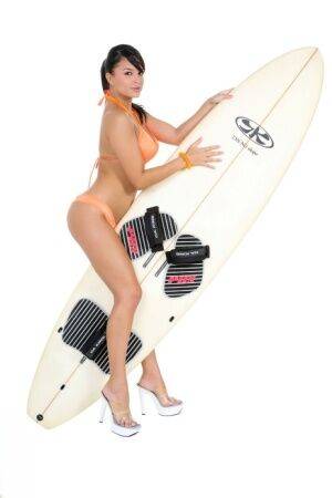 Sexy surfer girl Sarah peels off her bikini to model naked on her board on nudesceleb.com