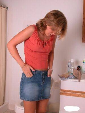 Amateur girl Karen hikes her denim skirt in the bathroom to expose her panties on nudesceleb.com