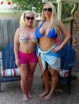 Blonde chicks Karen Fisher and Dee Siren loose their big tits from bikini tops on nudesceleb.com