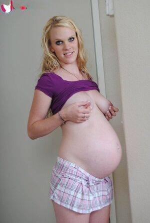 Blonde girl Hydii May puts her pregnant belly on display in knee socks on nudesceleb.com