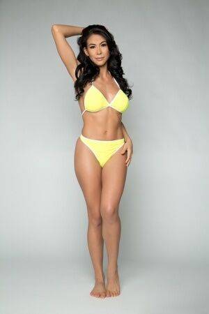 Brunette solo model Heather Vahn slowly peels off her yellow bikini on nudesceleb.com