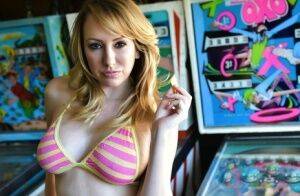 Brett Rossi fingers her pussy in striped OTK socks atop pinball machine on nudesceleb.com