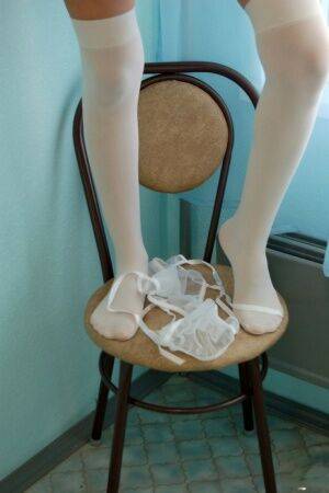 Thin brunette strips to white over the knee stockings on kitchen stool on nudesceleb.com