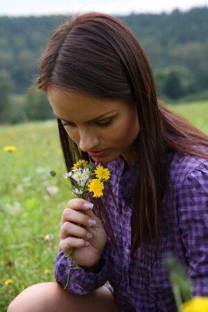 Young girl gets totally naked while picking flowers in a rural field on nudesceleb.com