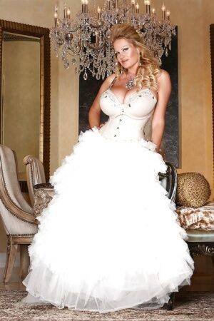 Kelly Madison is posing in a sexy wedding dress and white stockings on nudesceleb.com