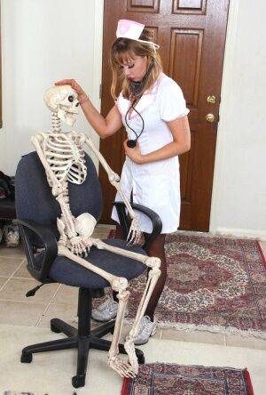 Sexy nurse Christy James peels her white uniform to facesit on a skeleton on nudesceleb.com