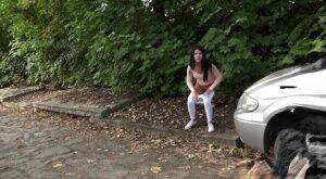 Dark haired girl Dee pulls down her white leggings for quick pee behind bushes on nudesceleb.com