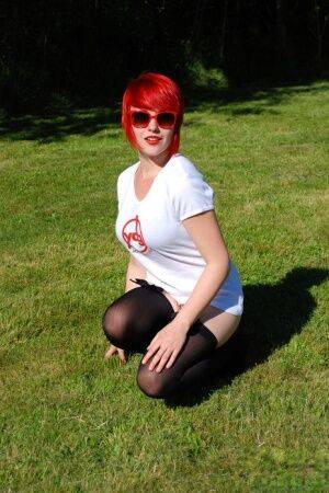 Redheaded amateur Sabrina soaks her white T-shirt out on a lawn in sunglasses on nudesceleb.com