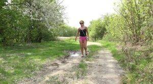 White girl Dafne pisses in a mud puddle while out for a walk in sunglasses on nudesceleb.com