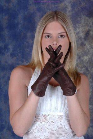 Blonde female pulls on brown leather gloves while wearing a white dress on nudesceleb.com