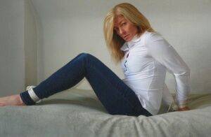 Blonde woman is cleave gagged and hogtied in a white blouse and blue jeans on nudesceleb.com