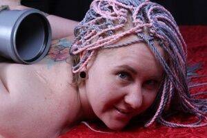 Barefoot white girl is hogtied to a post while face down on a bed on nudesceleb.com