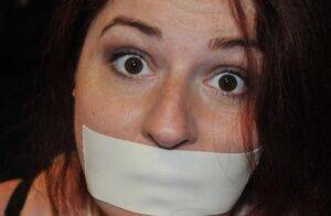 White girl is silenced with medical tape while tied up in her clothing on nudesceleb.com