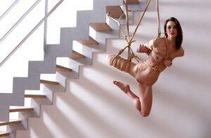 Naked white girl is suspended in midair by ropes with no one else around on nudesceleb.com