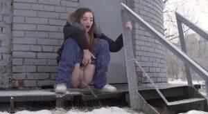 White girl pulls down her jeans to pee in the snow behind a building on nudesceleb.com