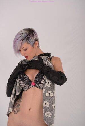 Solo girl with short dyed hair bares her tits and twat in long leather gloves on nudesceleb.com