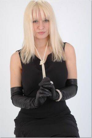 Natural blonde exposes some thigh while wearing long leather gloves on nudesceleb.com