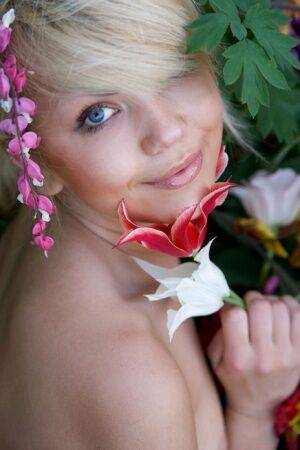 Cute young blonde Iveta poses in the nude while in a garden on nudesceleb.com