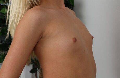 Sassy blondie undressing and teasing her shaved cunt with her fingers on nudesceleb.com