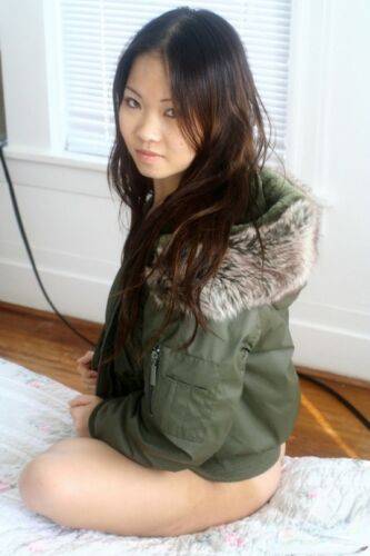 Asian amateur Grace removes a winter coat to model a thong during SFW action on nudesceleb.com