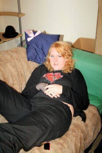 Redheaded fatty strips her sweatshirt and shows her cleavage in a black bra on nudesceleb.com