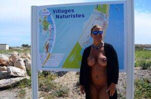 Mature fatty Chrissy walks by the sea with her round big tits bared on nudesceleb.com