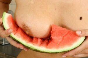 Blonde vixen Flower undressing in the kitchen to eat melon with bare big tits on nudesceleb.com