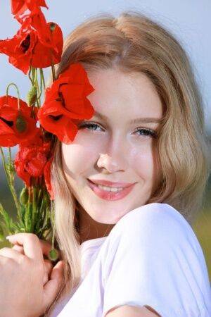 Sweet teen Genevieve Gandi strips naked in a field of blooming flowers on nudesceleb.com