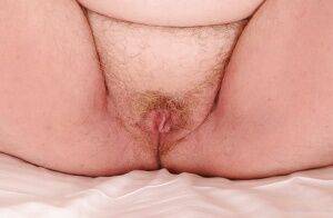 Mature plumper with huge saggy jugs and hairy cooter posing on the bed on nudesceleb.com
