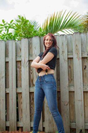 Hot redhead Andy Adams loses her t-shirt & jeans in the yard to pose naked on nudesceleb.com