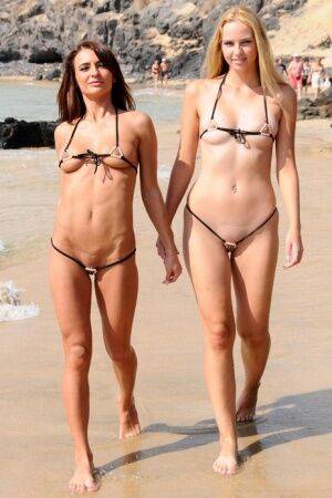 Best friends model revealing bikinis while wondering about a mud flat on nudesceleb.com