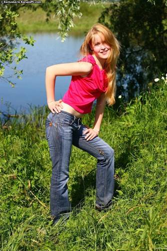 Sylphlike redheaded young Alina in jeans denudes tiny tits and shaved pussy outside on nudesceleb.com