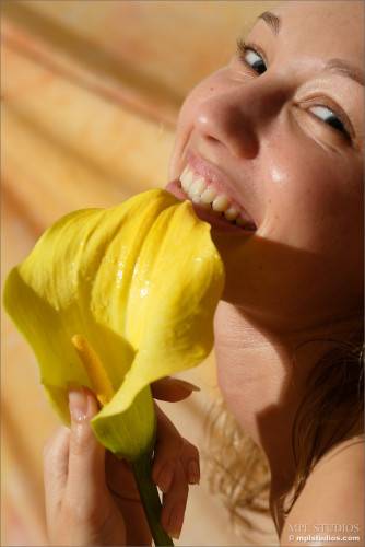Masha P Is Lying On Silk Sheet And Gently Fondling Her Smooth Body With Yellow Flower on nudesceleb.com