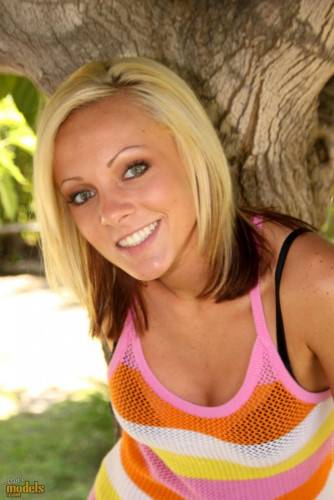 Smiling Blonde Kitty Cali Kayden Shows Her Bald Pussy In The Shadow Of A Tree on nudesceleb.com