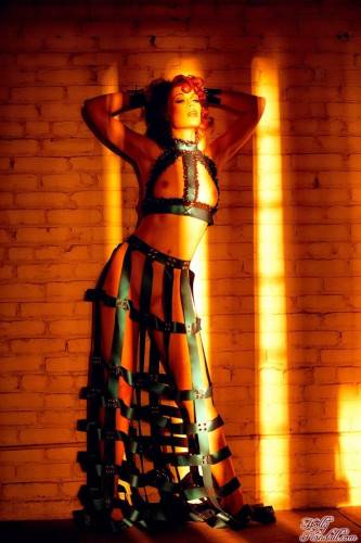 Redhead Justine Joli In Amazing Dress Made Of Leather Belts Poses In The Empty Room on nudesceleb.com
